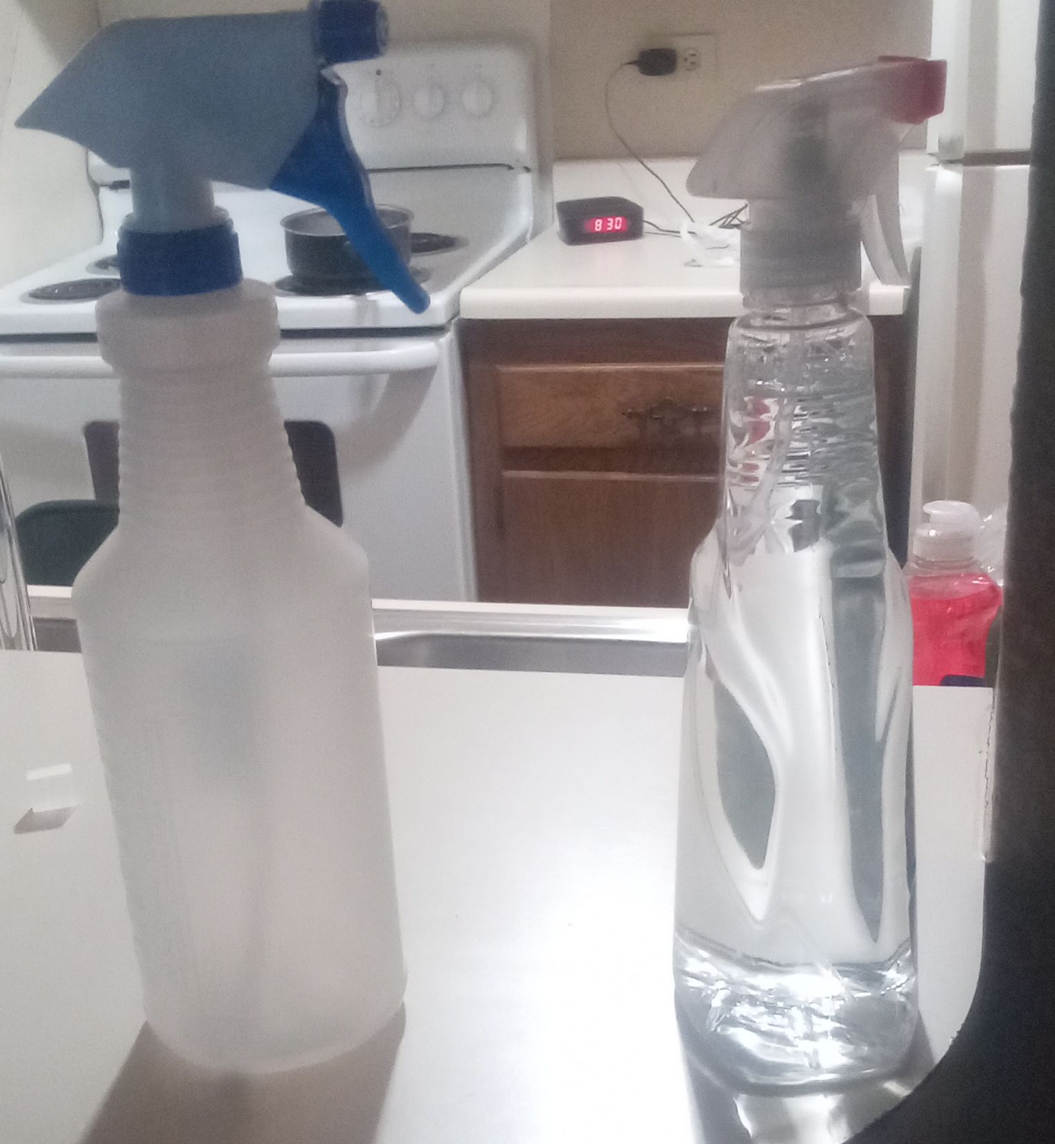 A window cleaner bottle and empty spray bottle, representing cleaning product formulas, chemical inventory, packaging, and batch tracking.
